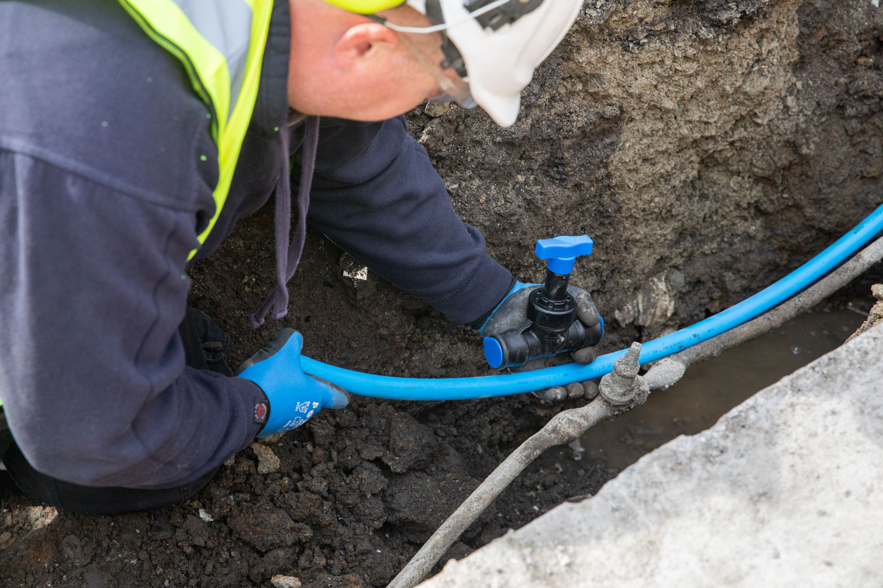 Uisce Éireann worker fixing pipes in the ground