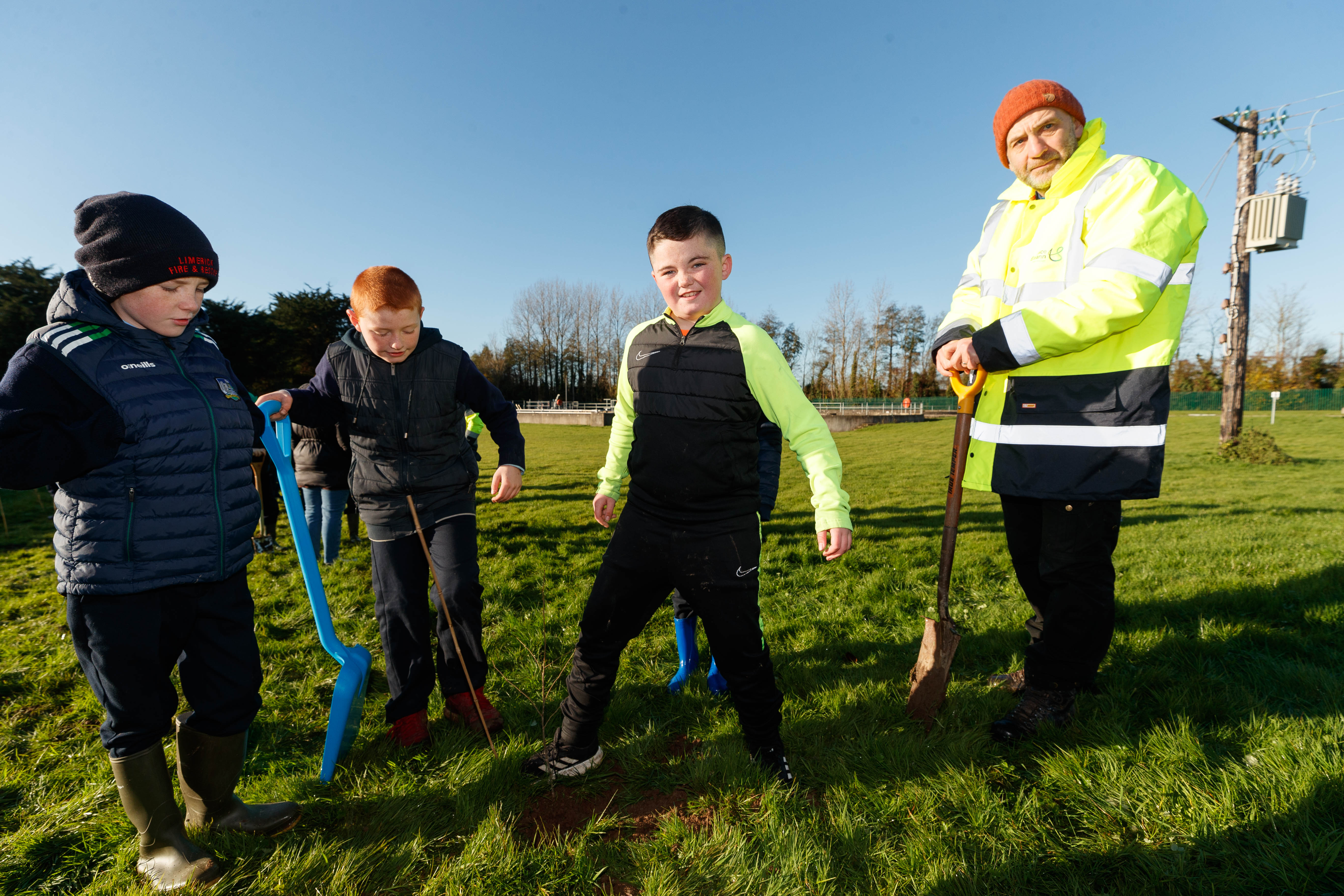 An Uisce Éireann worker and three kids with shovels