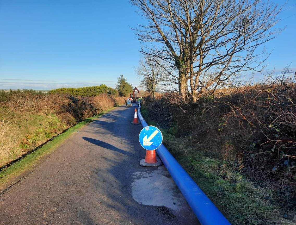 A large blue pipe on a small road