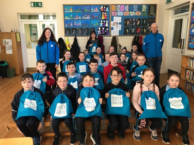 A group of schoolchildren holding Uisce Éireann bags