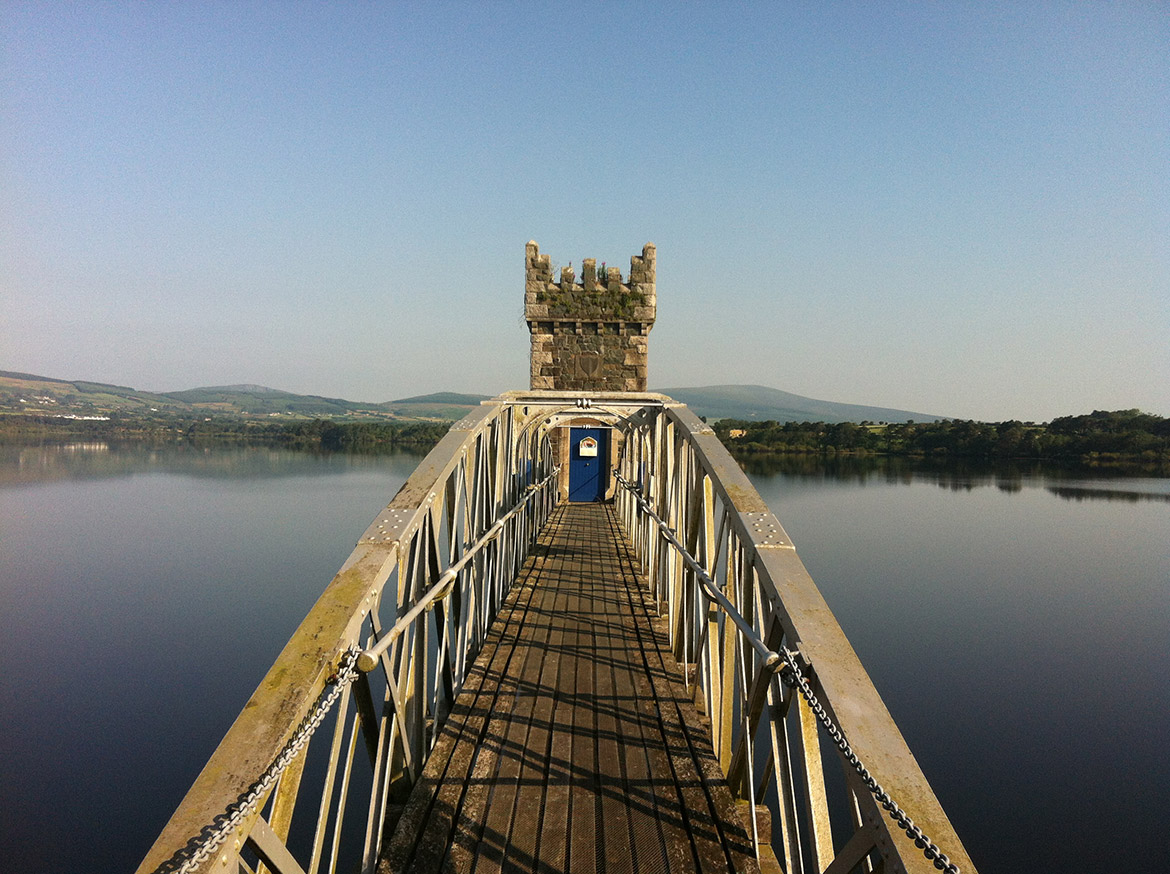 A bridge with a turret over a lake