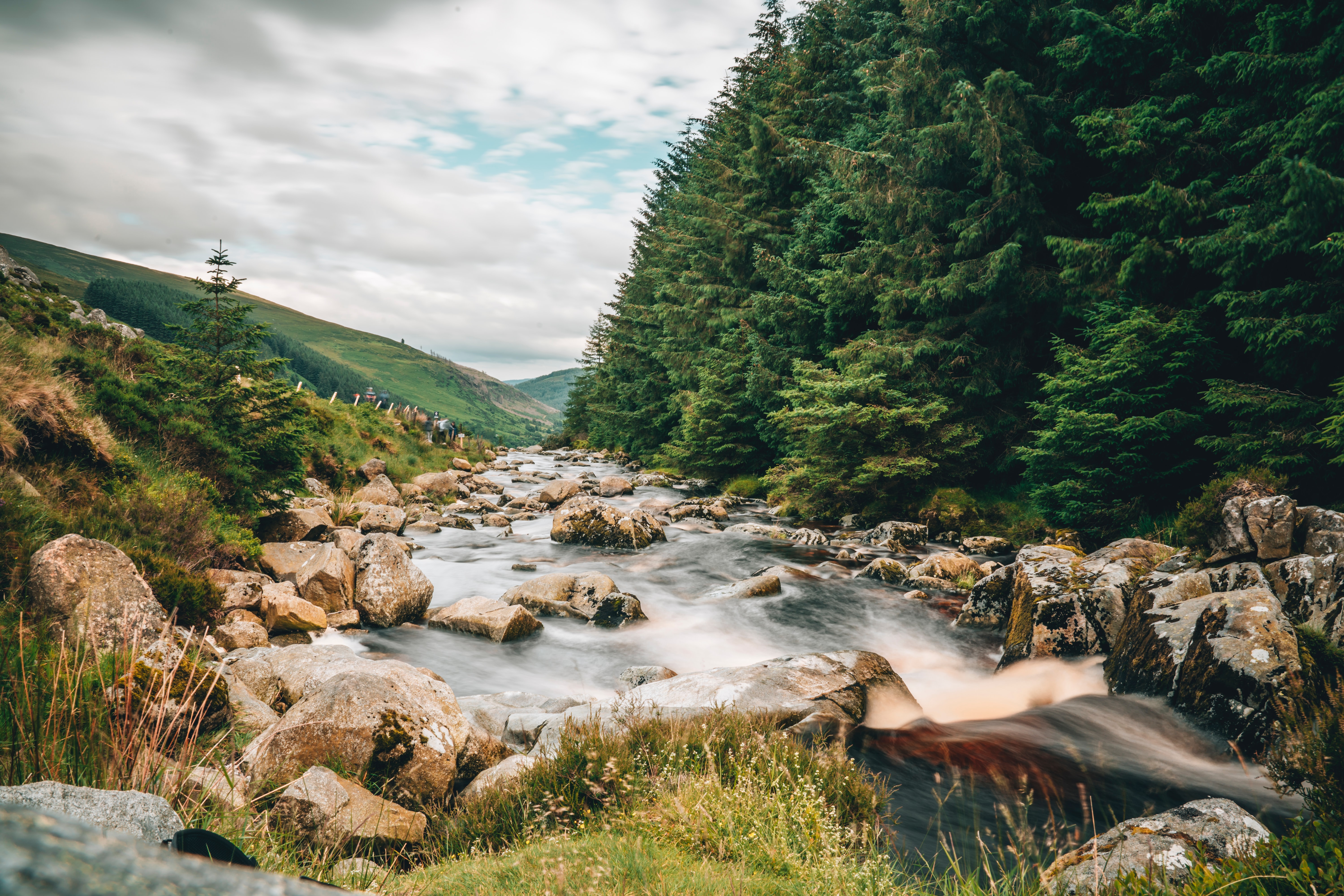 Rocky river by a forest and some hills