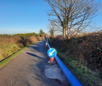 A large blue pipe on a small road